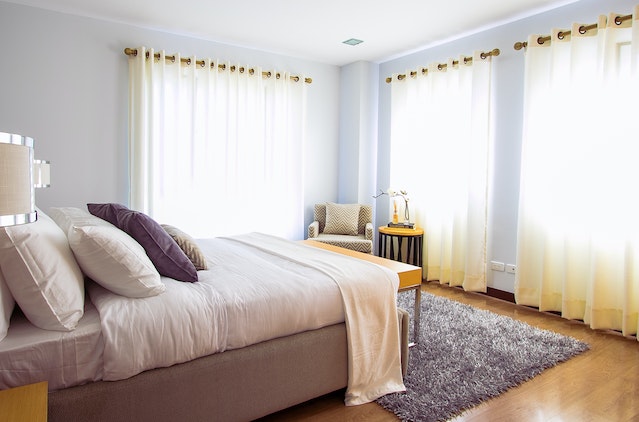 bed in bedroom with closed curtains